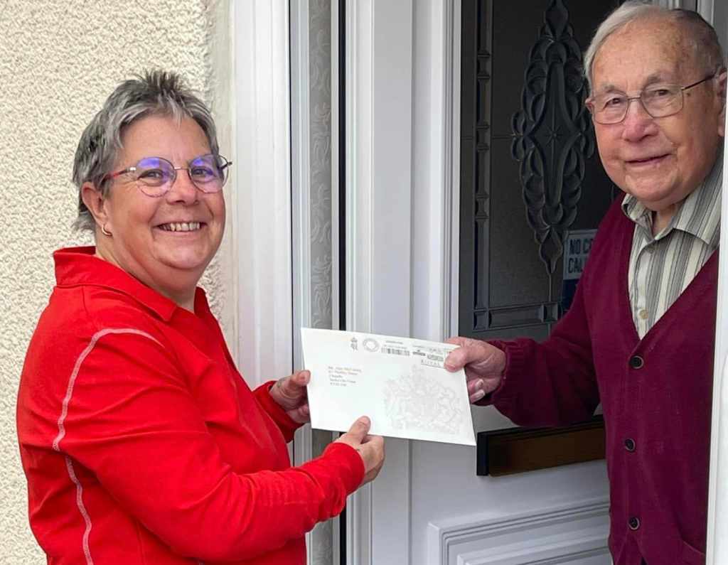 Above: Postie Diane delivers 100th birthday greetings to her dad Alec