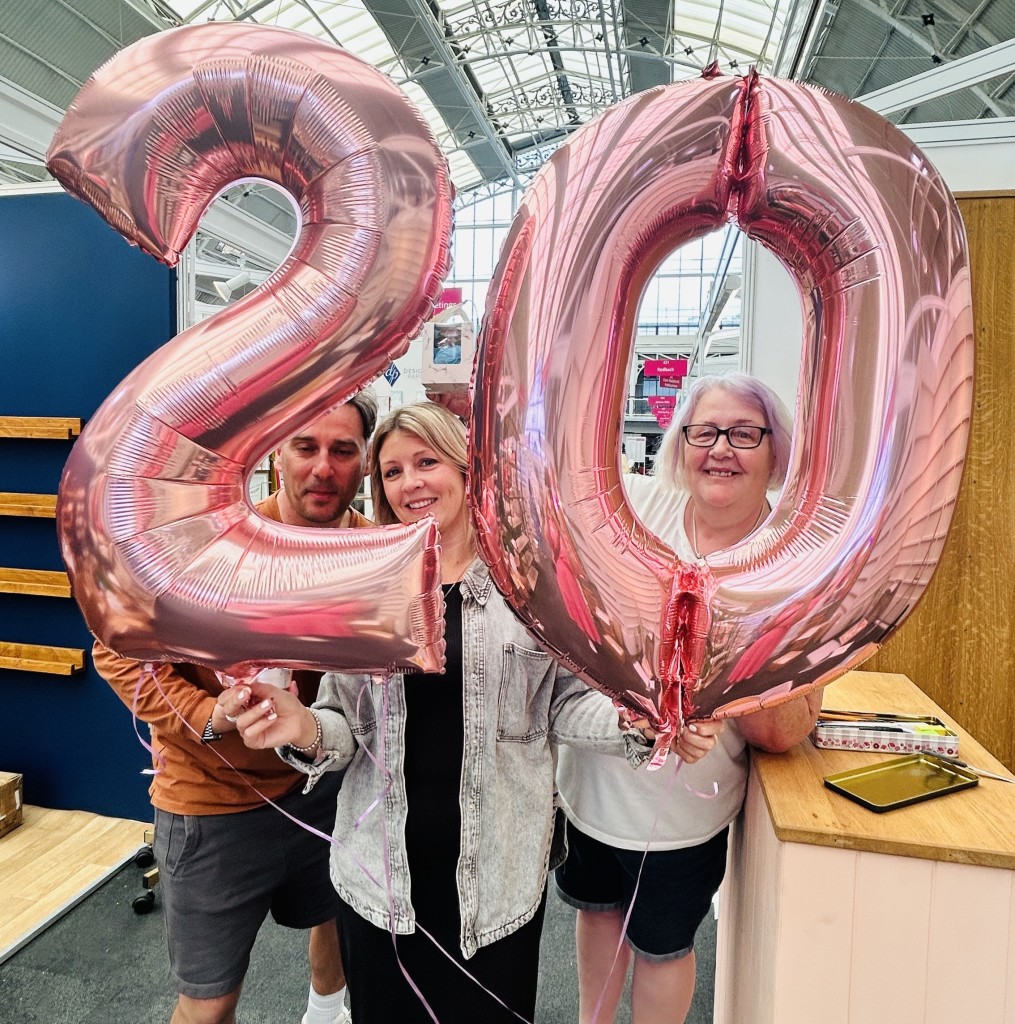 Above: All set to party at Laura Darrington Design (stand 417) where Laura and Ross Harrington are celebrating 20 years in business with a gift from PG’s Tracey Arnaud (right)